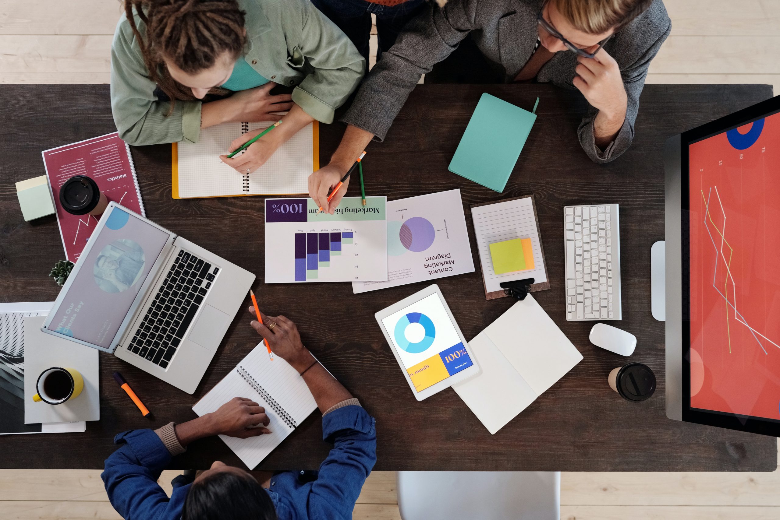 People sitting around a desk discussing sales graphs